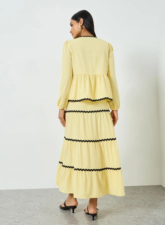 Ensemble composé d'un haut jaune à nouer orné de galons et d'une jupe longue à volants