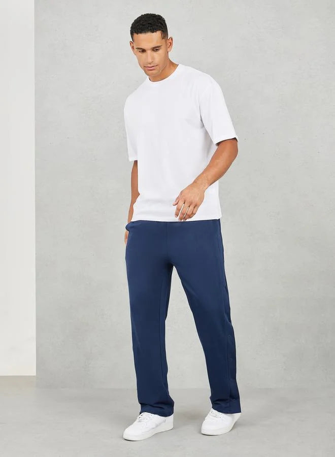 Pantalon de jogging oversize à jambes droites et ourlet ouvert avec boutons-pression