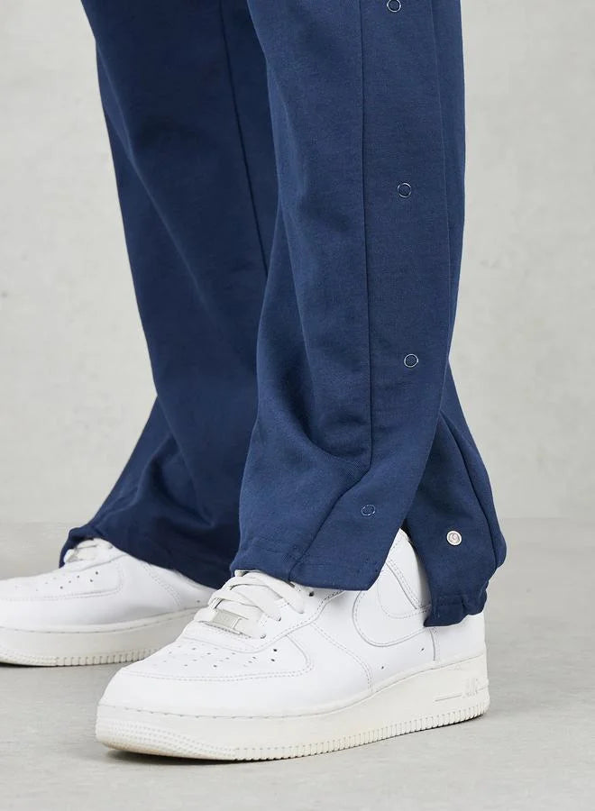 Pantalon de jogging oversize à jambes droites et ourlet ouvert avec boutons-pression